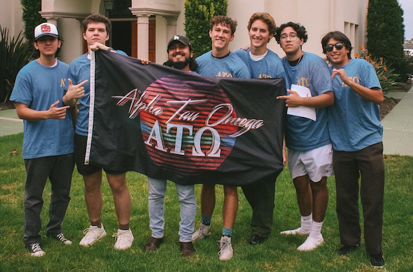 group of students holding up a Alpha Tau Omega flag